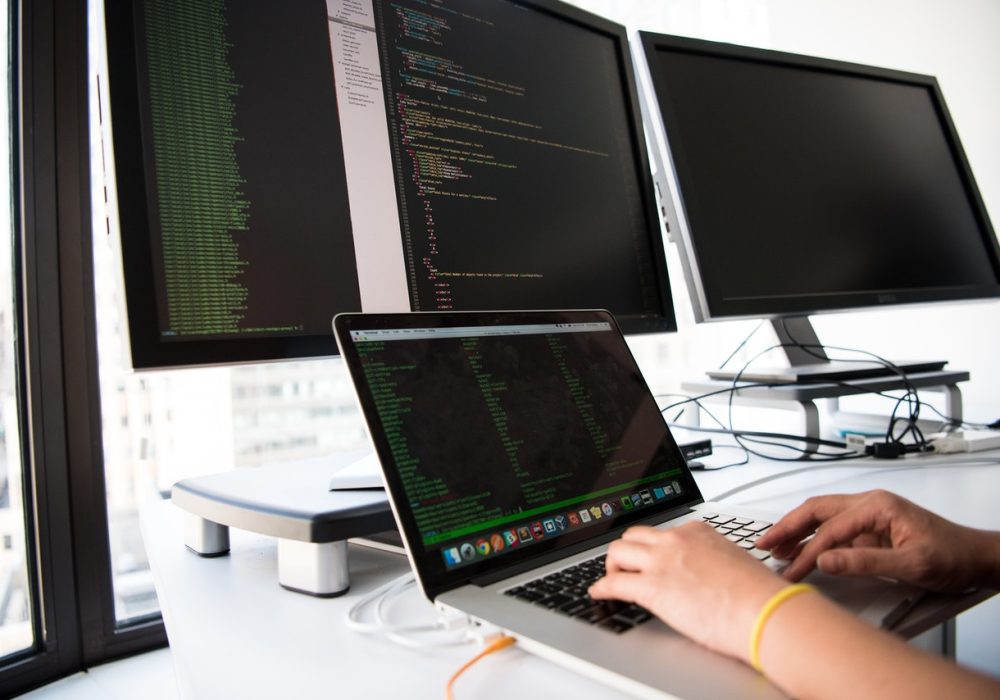 person working in front of computer with multiple monitors person working in front of computer with multiple monitors