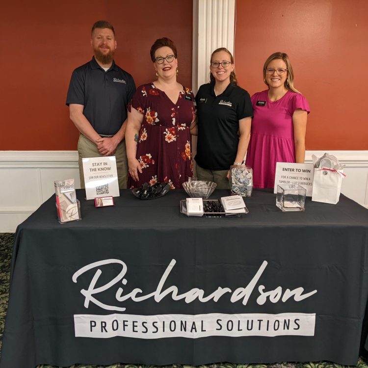 RPS team members at a promotional event standing behind decorated promotional table, Fort Gordon 2021